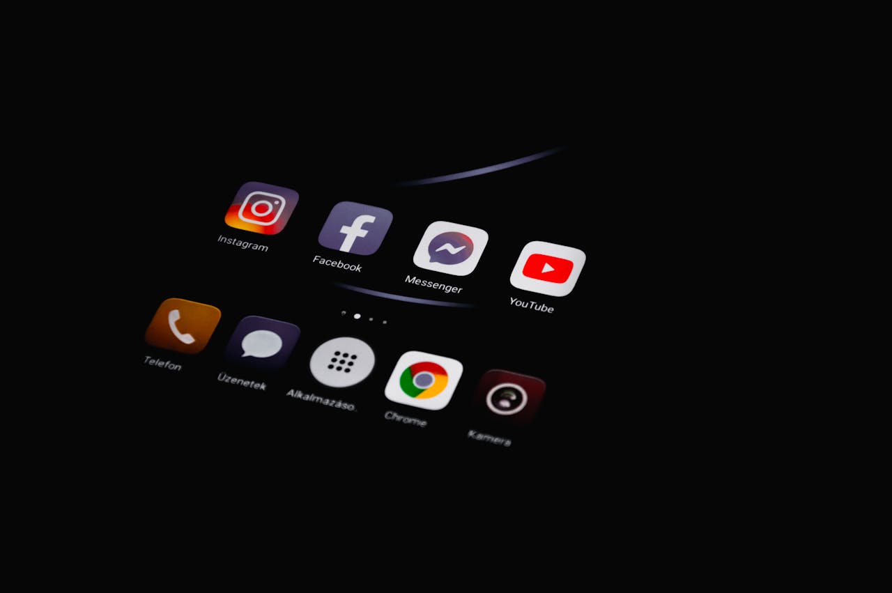 Close-up of smartphone displaying popular social media apps in dim lighting.