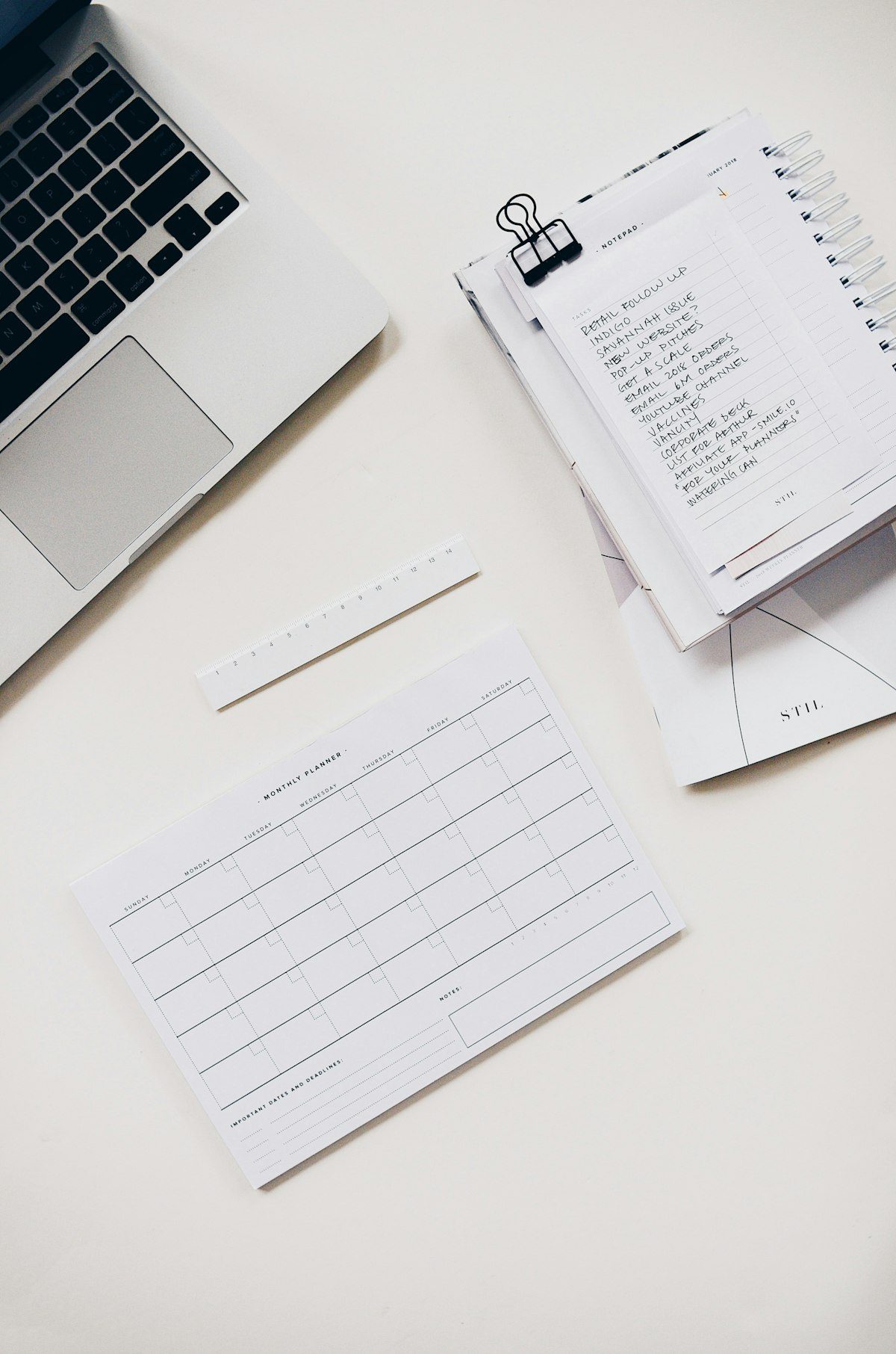 Laptop and handwritten notebook used to gather work history and achievements before writing a resume